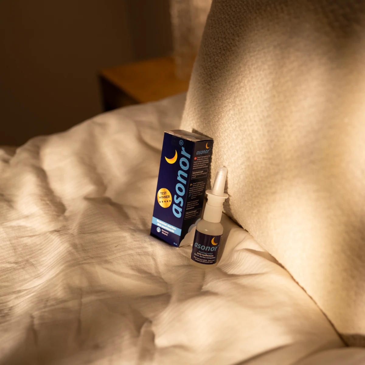 Asonor bottle and carton beside a pillow